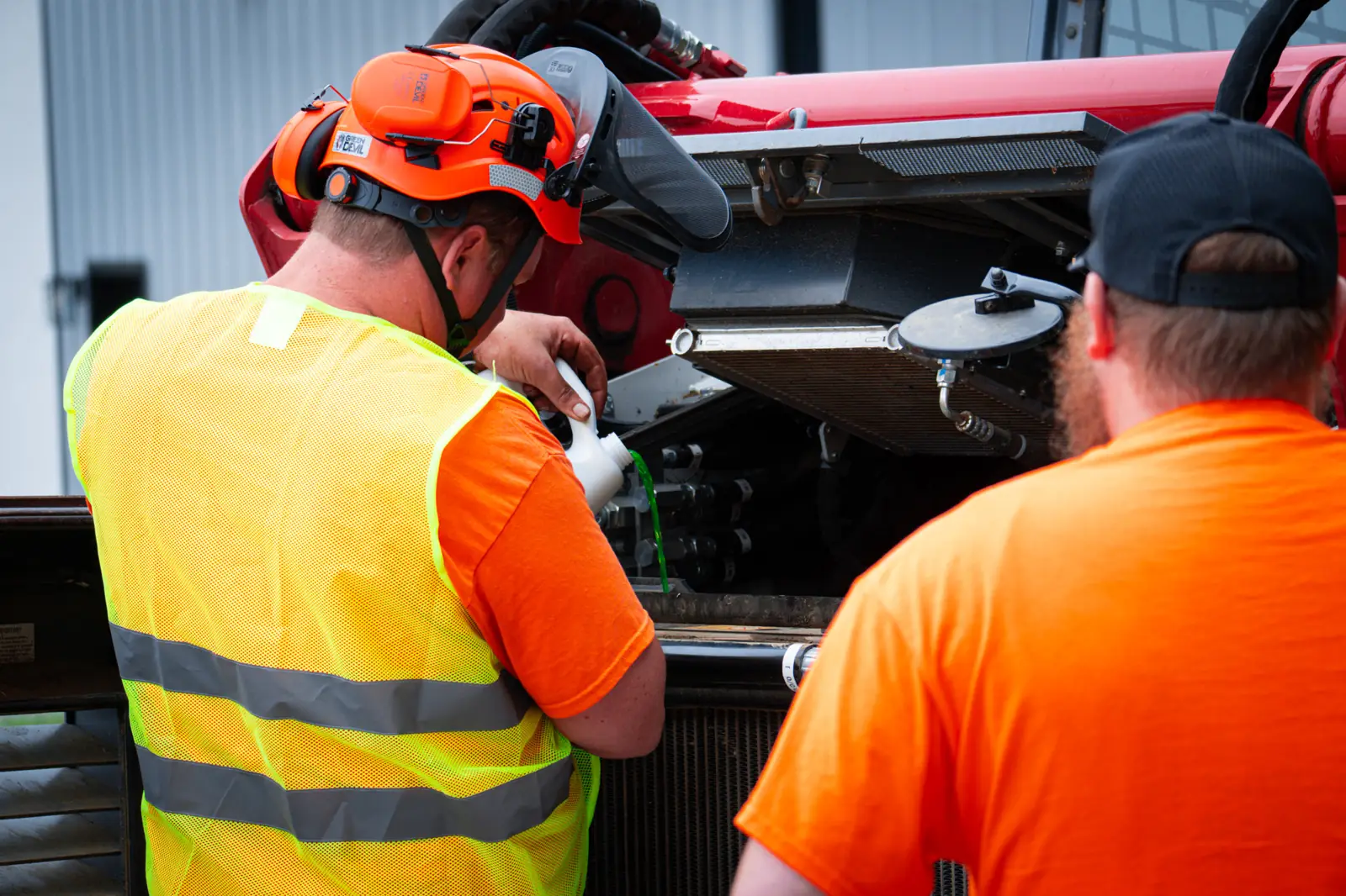 Brushworks crew servicing a track loader before heading out