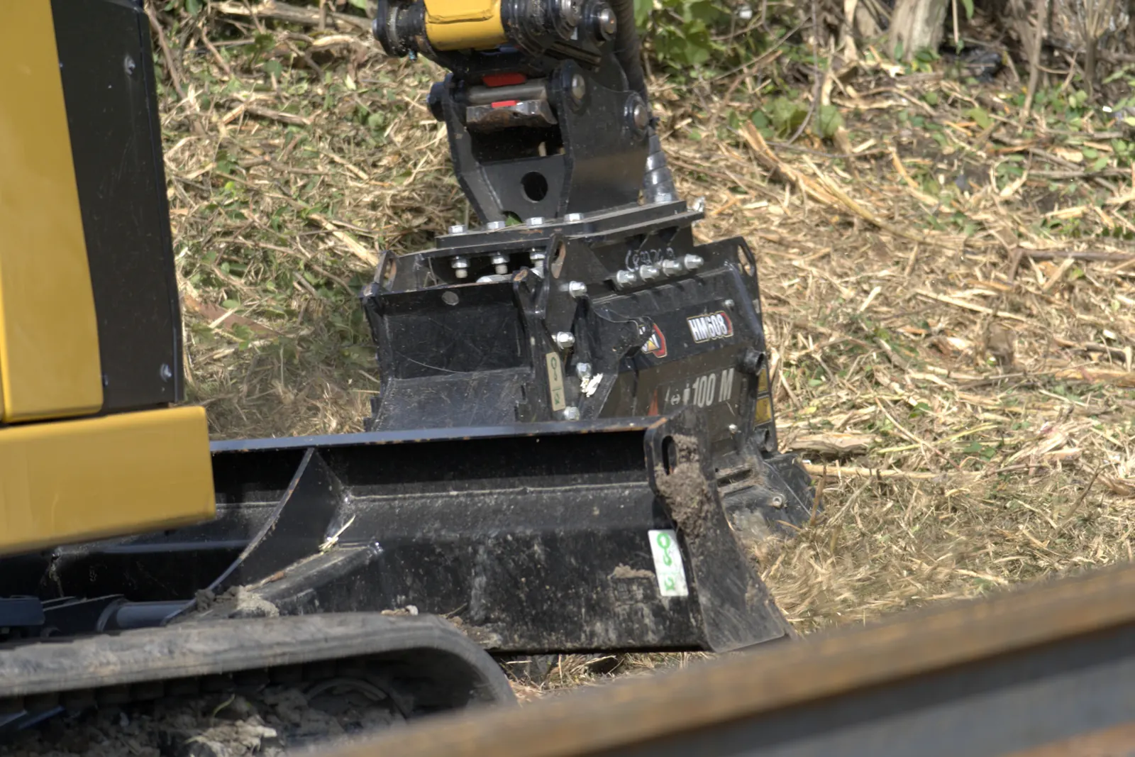 Close view of an excavator mulching head over freshly cut brush