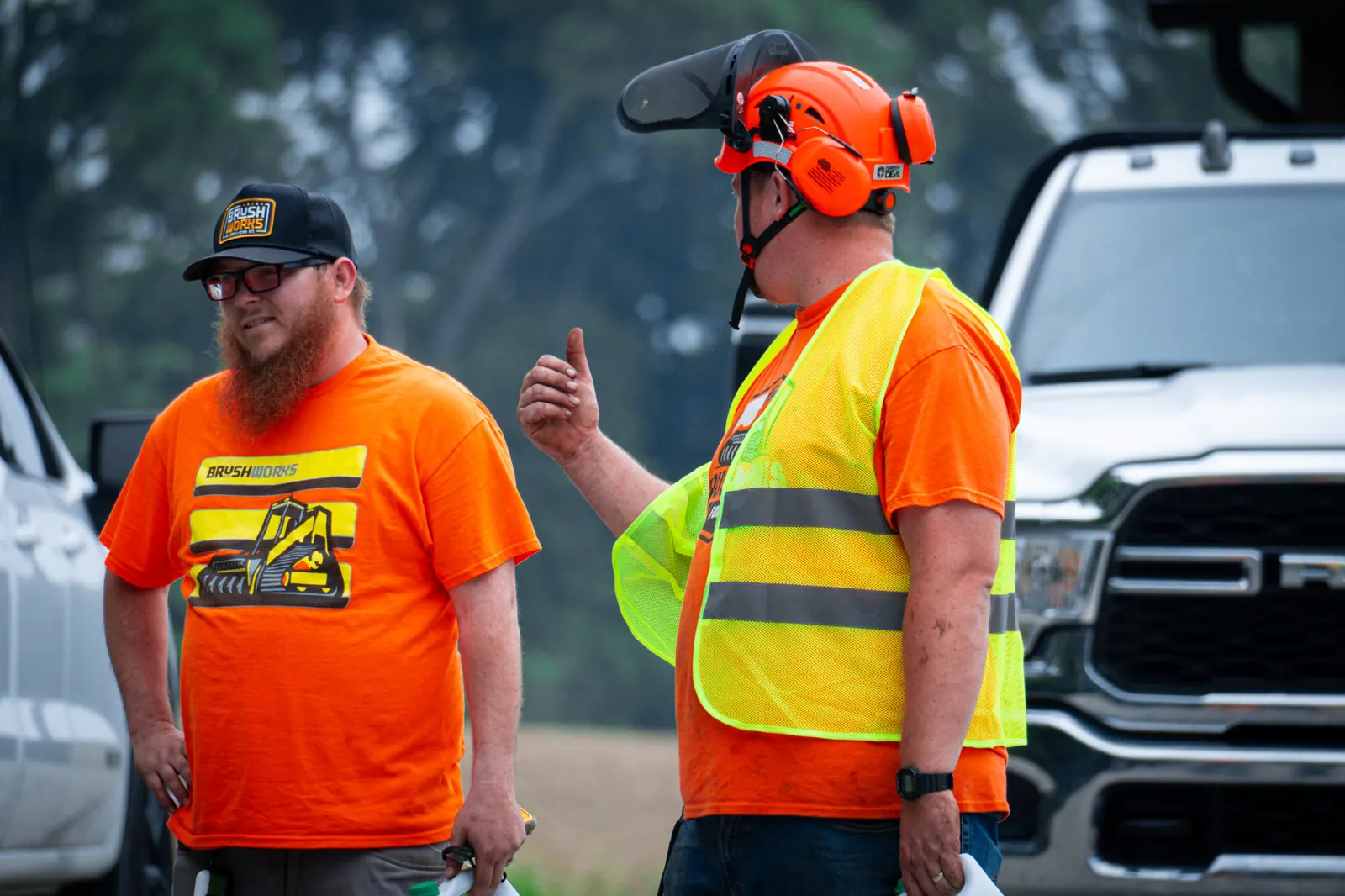 Brushworks crew members talking through the clearing plan beside a company truck