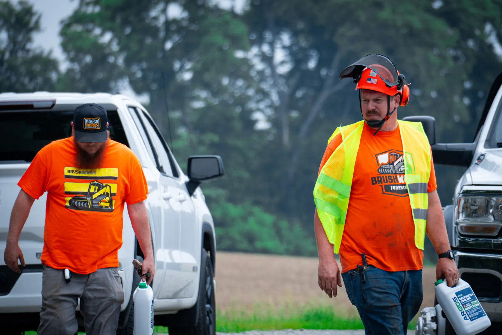 Two Brushworks crew members walking a job site to their truck