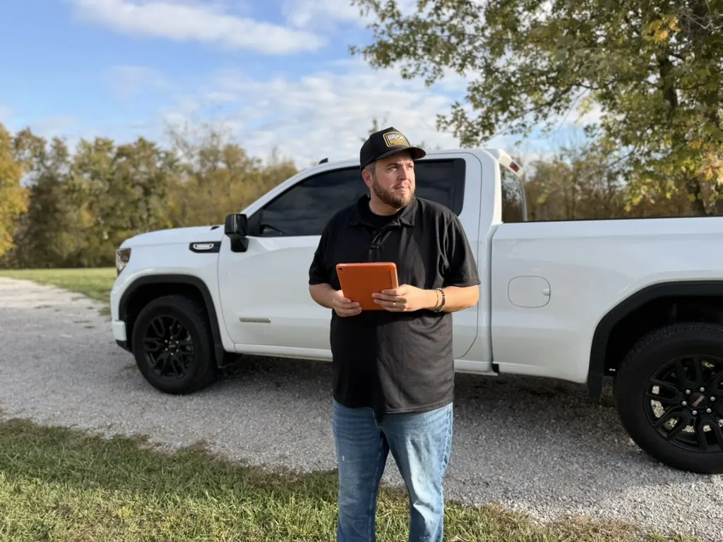 Brushworks owner walking a property with a clipboard to plan a honeysuckle clearing
