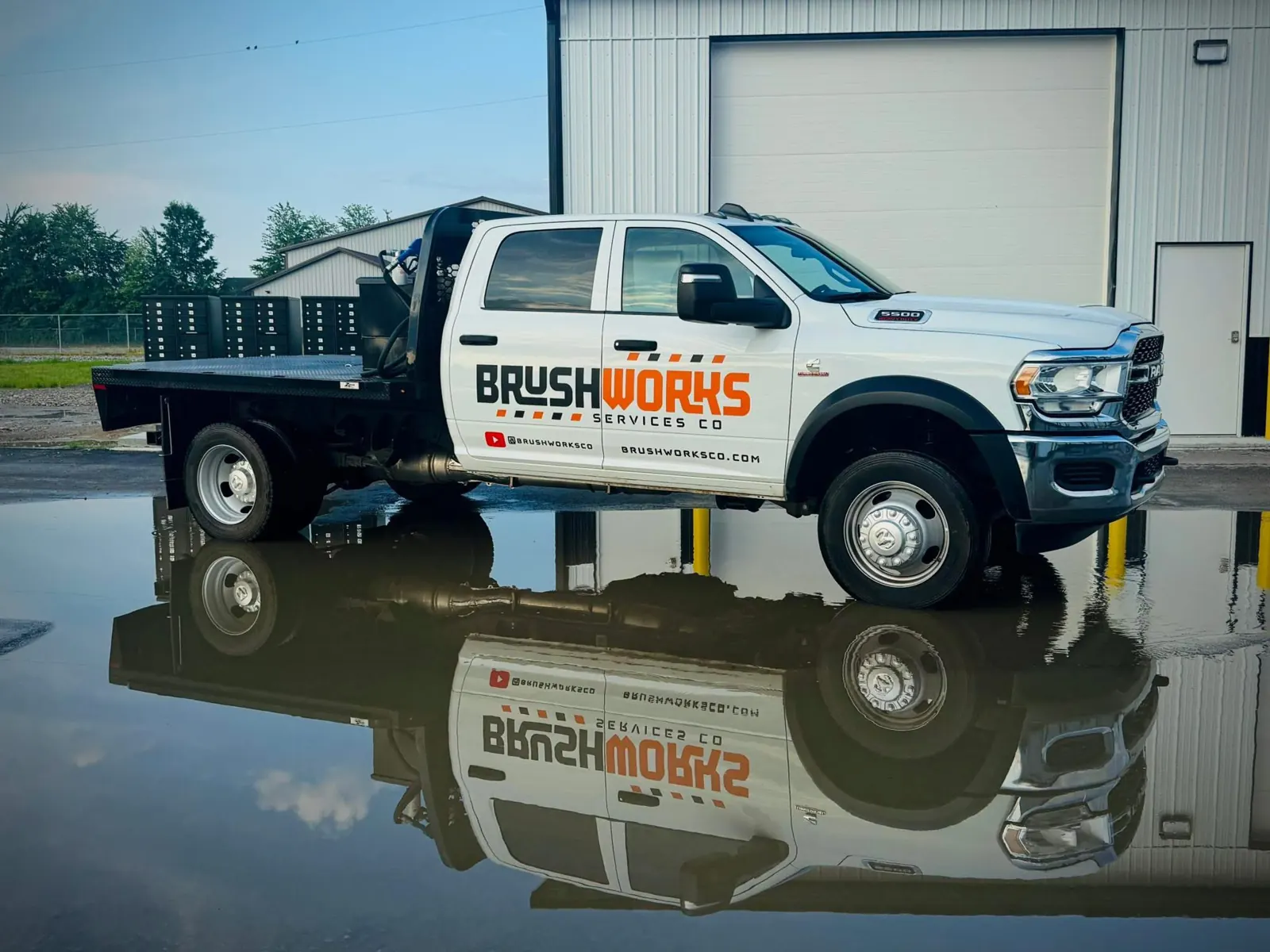 Brushworks flatbed work truck parked at the shop after a job