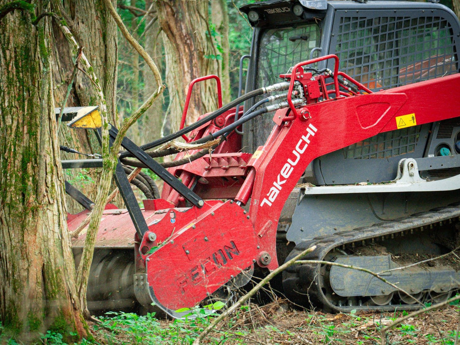 Real Takeuchi TL12 cutting into brush along a woodline