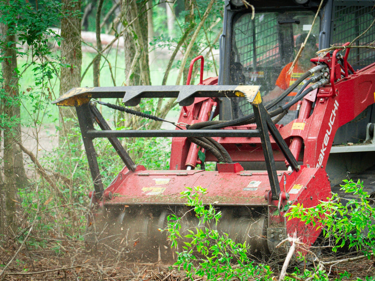 Real Takeuchi TL12 with Fecon mulching head actively processing brush
