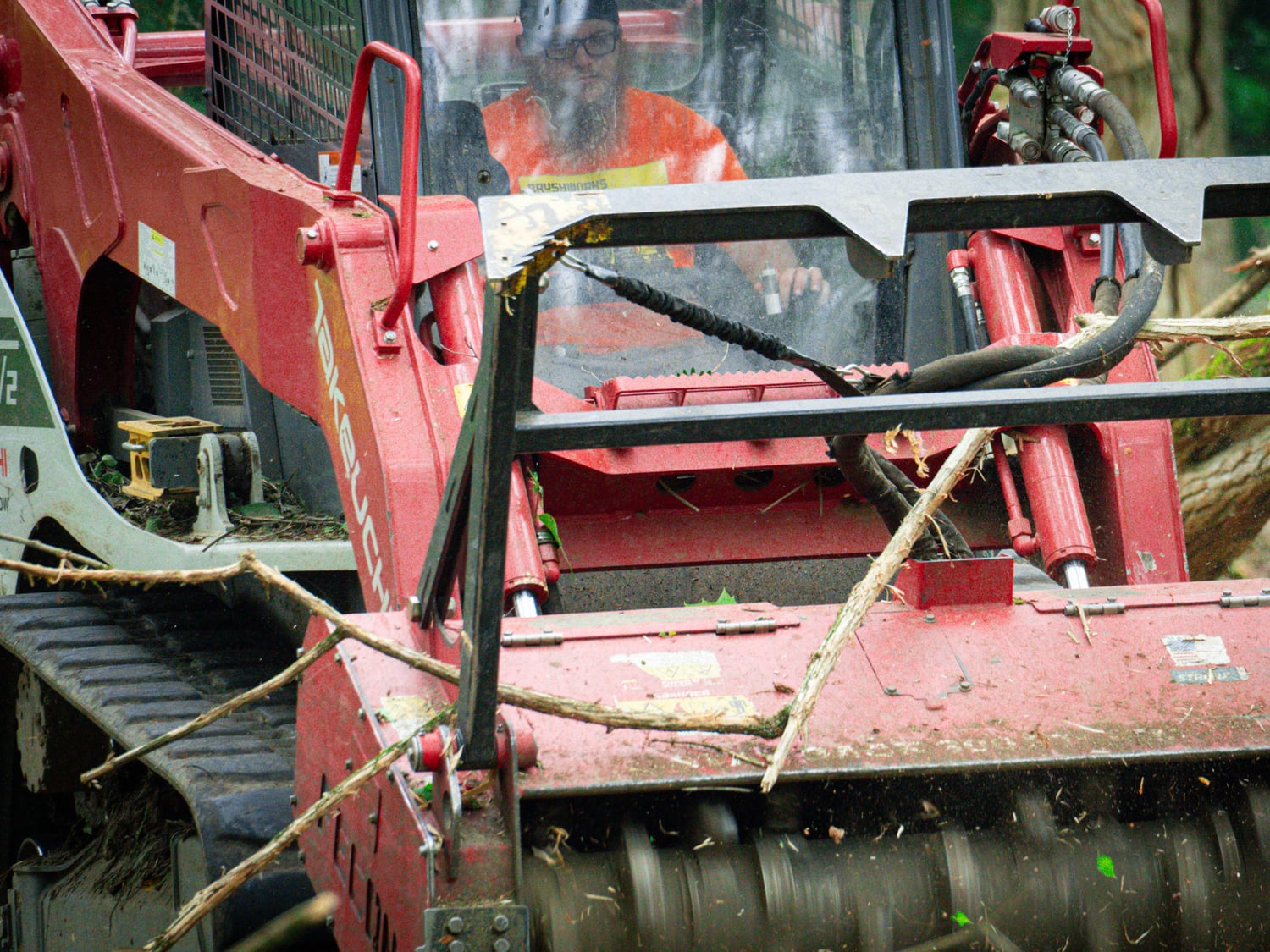 Front view of a real Fecon mulching head processing brush and soil cover