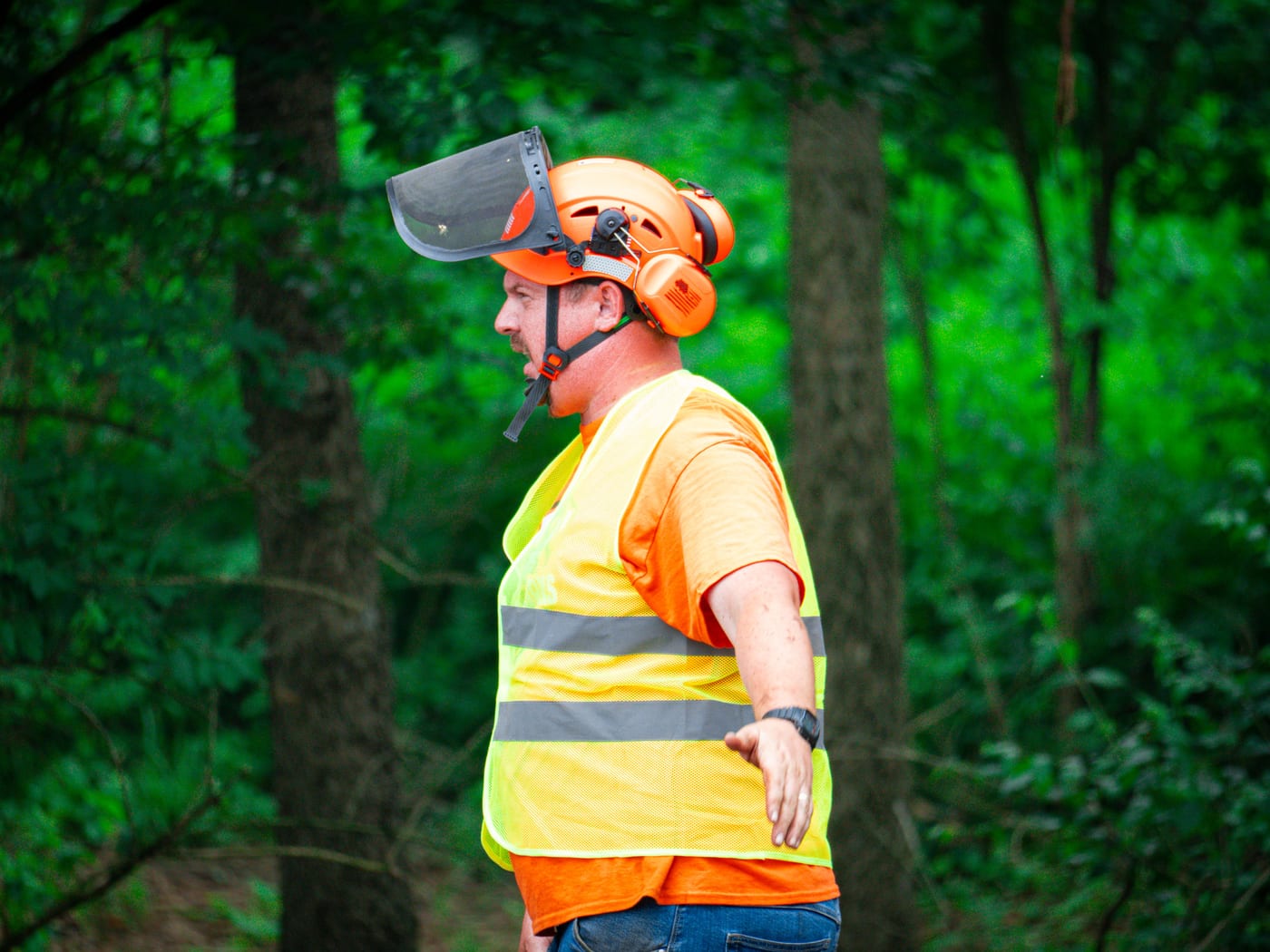 Brushworks team member guiding work in a wooded clearing area