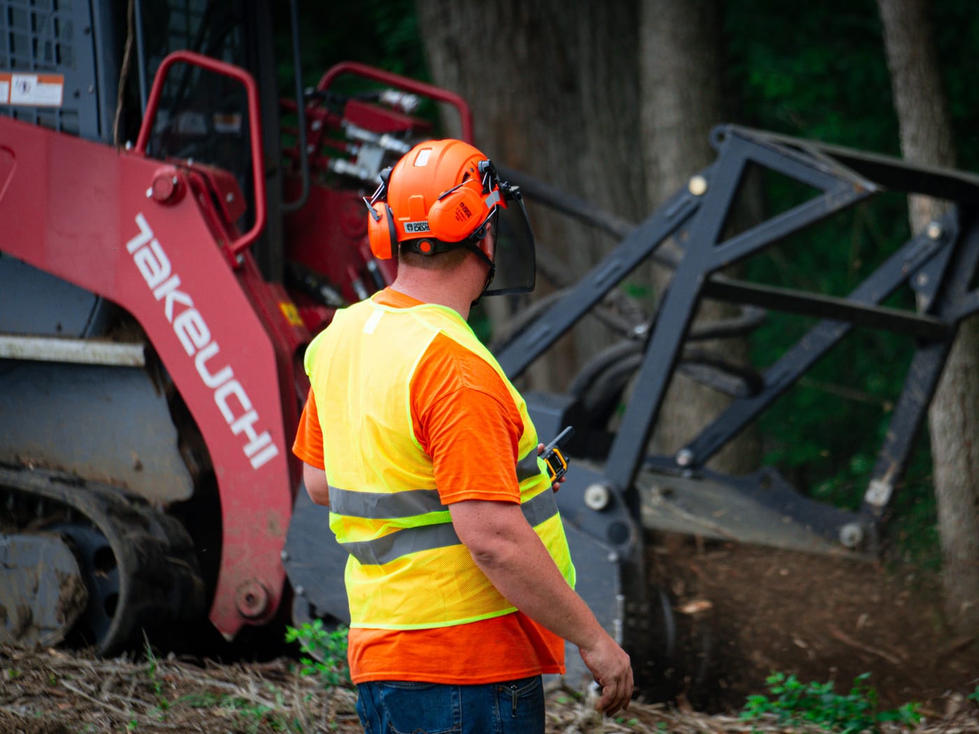 Brushworks team member working at the mulching attachment in the woods