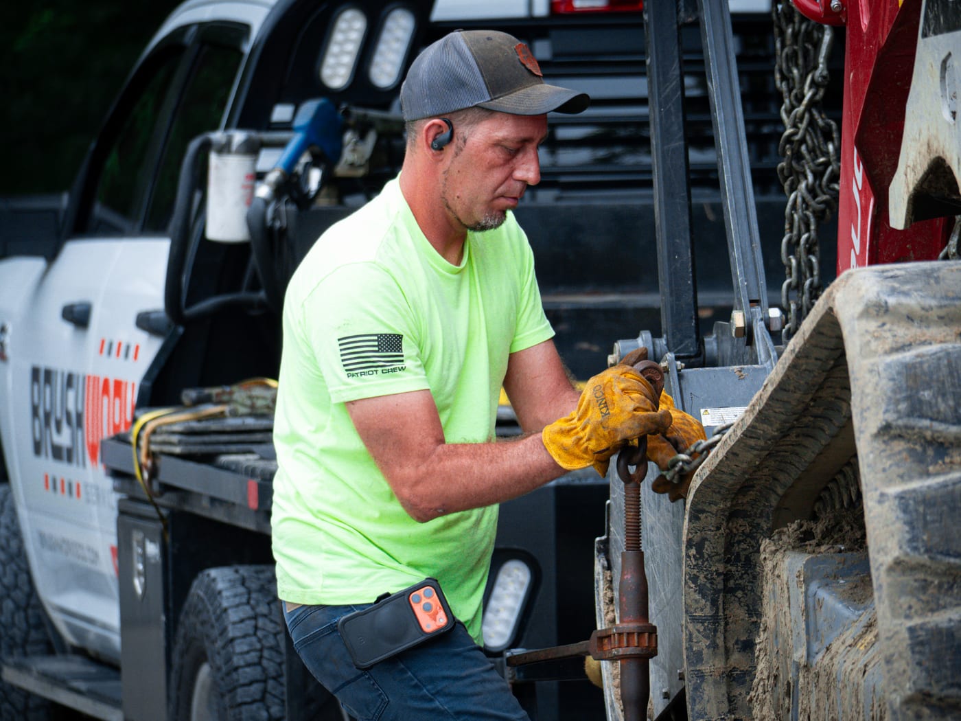 Brushworks crew member preparing a mulching attachment before work