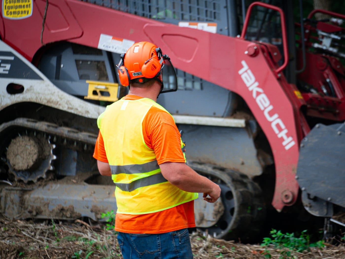 Brushworks crew member working beside the loader and mulching head