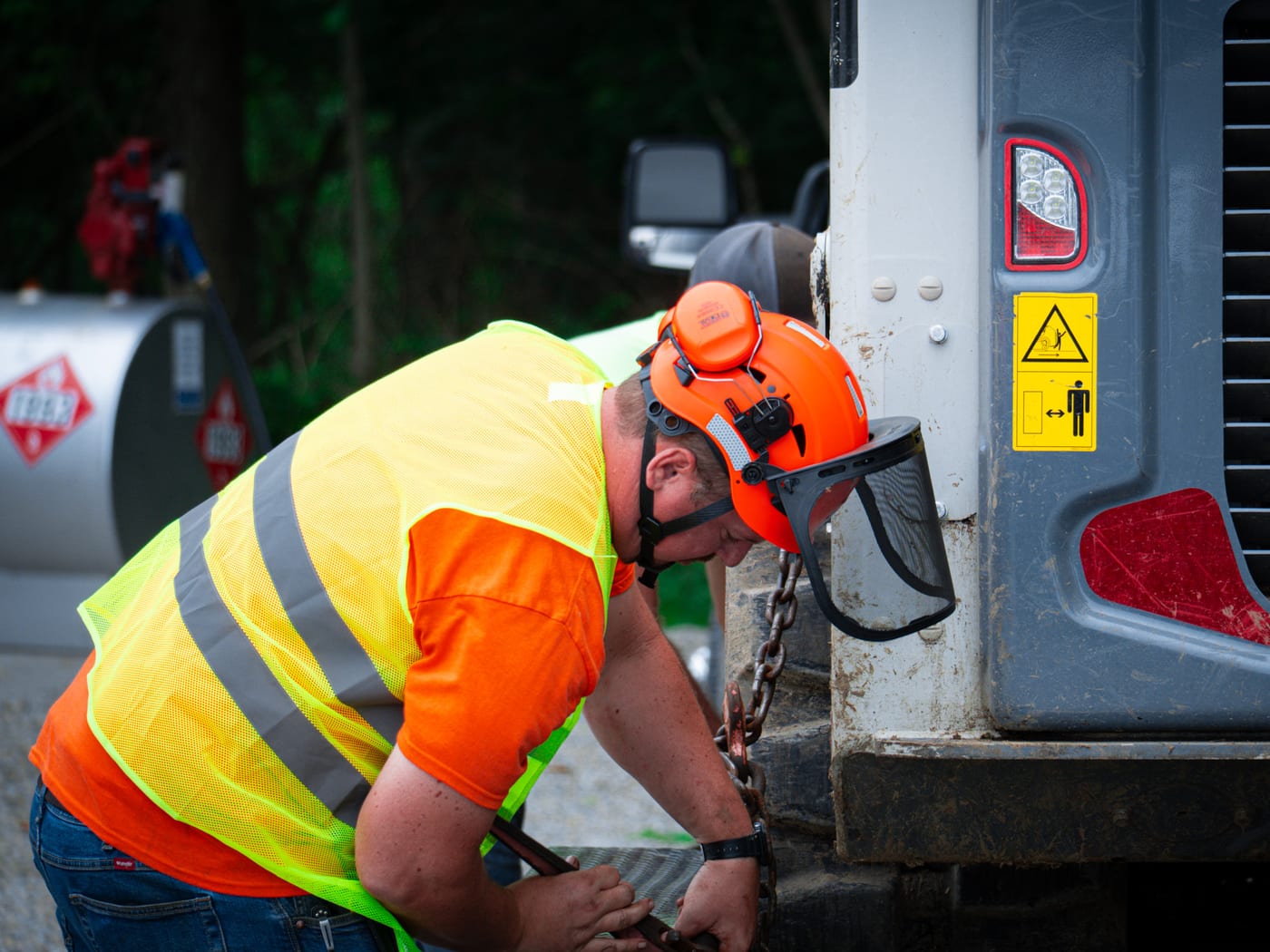 Brushworks team member checking equipment connections on a jobsite