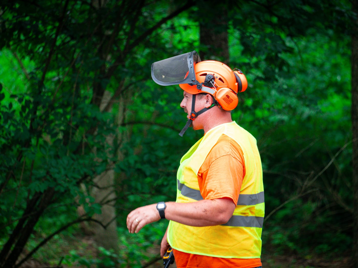 Brushworks team member walking the field in safety gear before clearing
