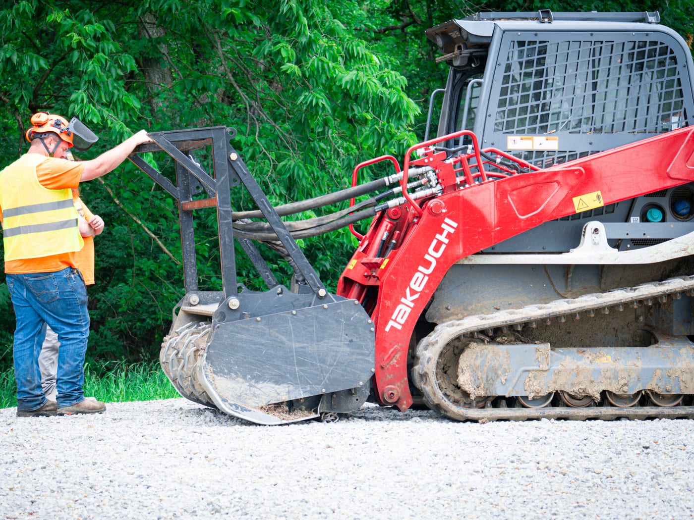 Brushworks team member working around the Takeuchi loader before clearing