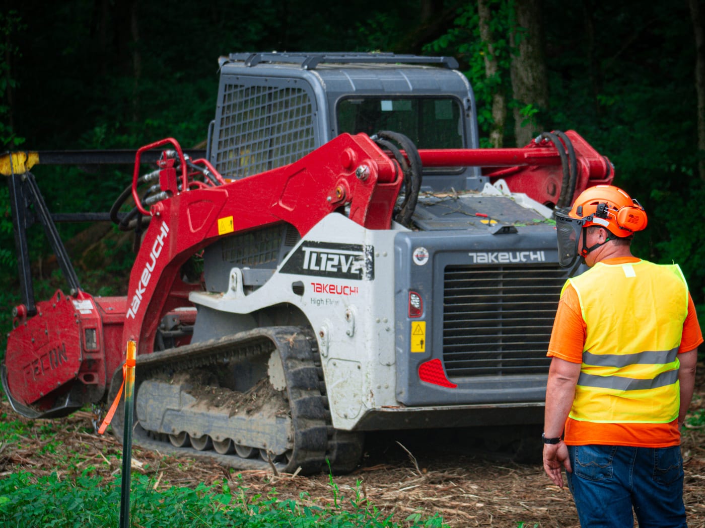 Brushworks crew member working beside the Takeuchi loader during field prep